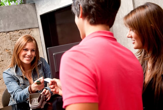 Couple at the hotel reception paying with a credit or debit card